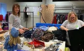 Voluntárias da Qualitrol classificando roupas doadas em centro de distribuição