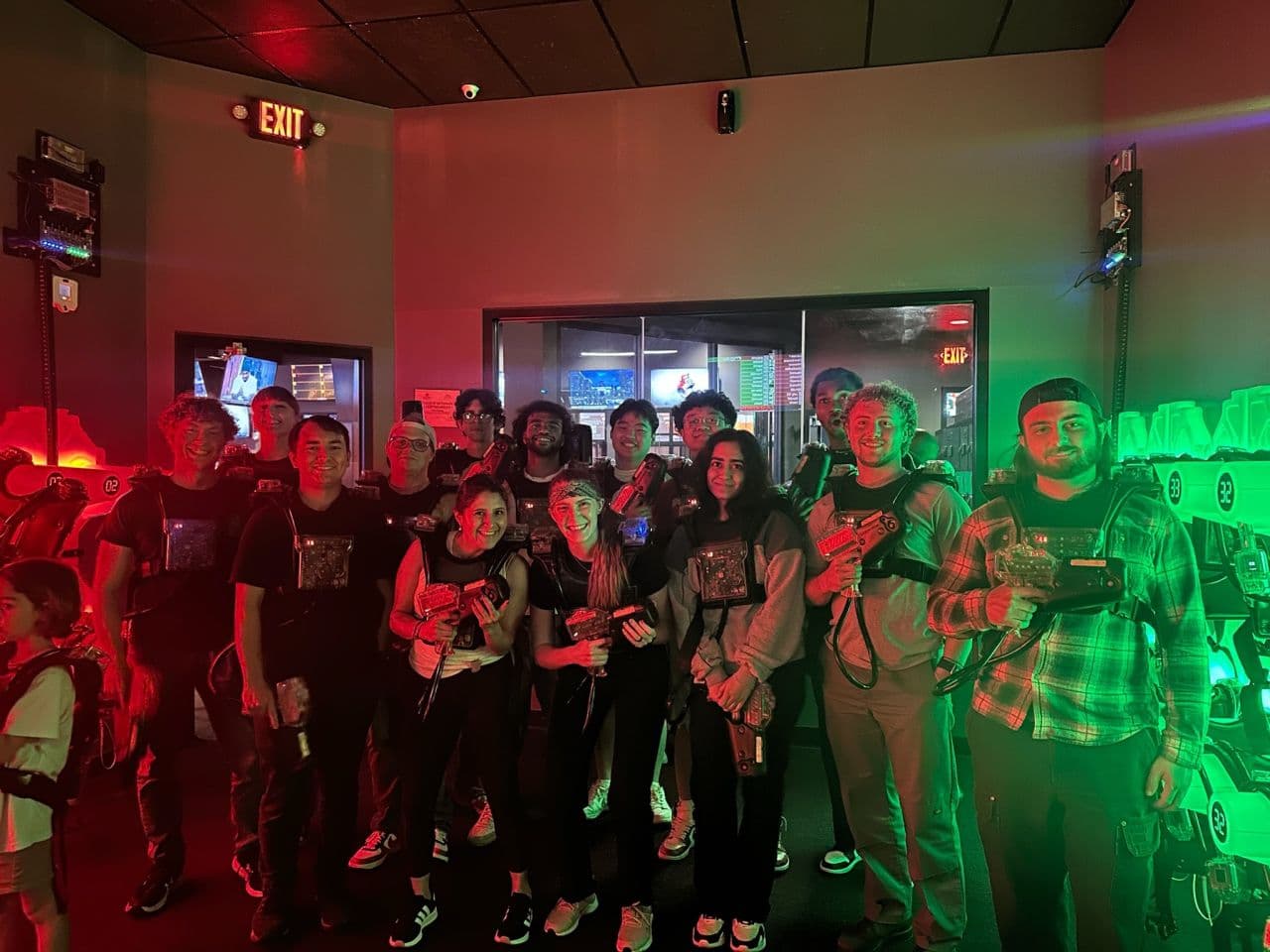 Grupo de participantes do programa cooperativo da Qualitrol jogando atividade de construção de equipe com laser tag